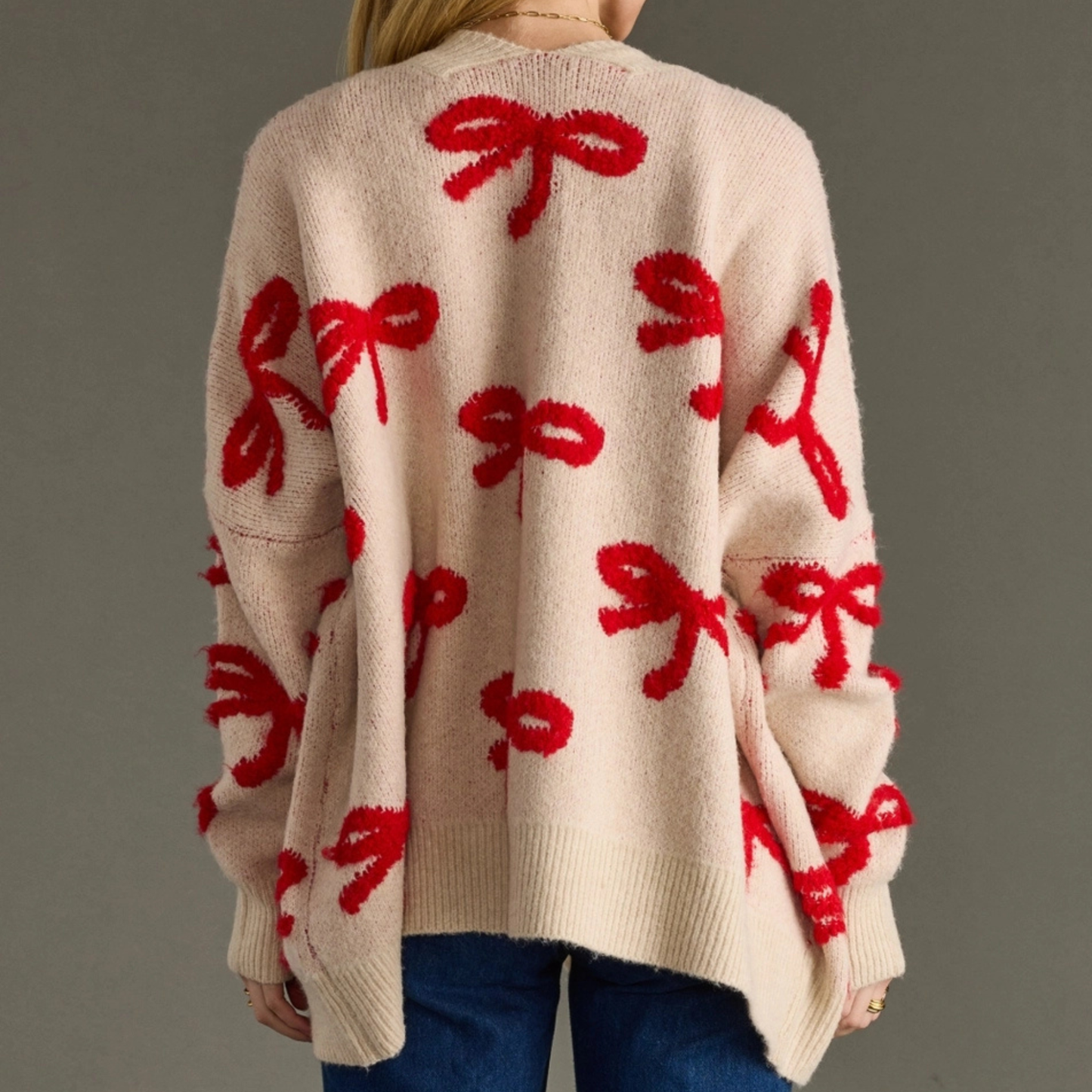Close-up of red bow detail on womenβs knit cardigan